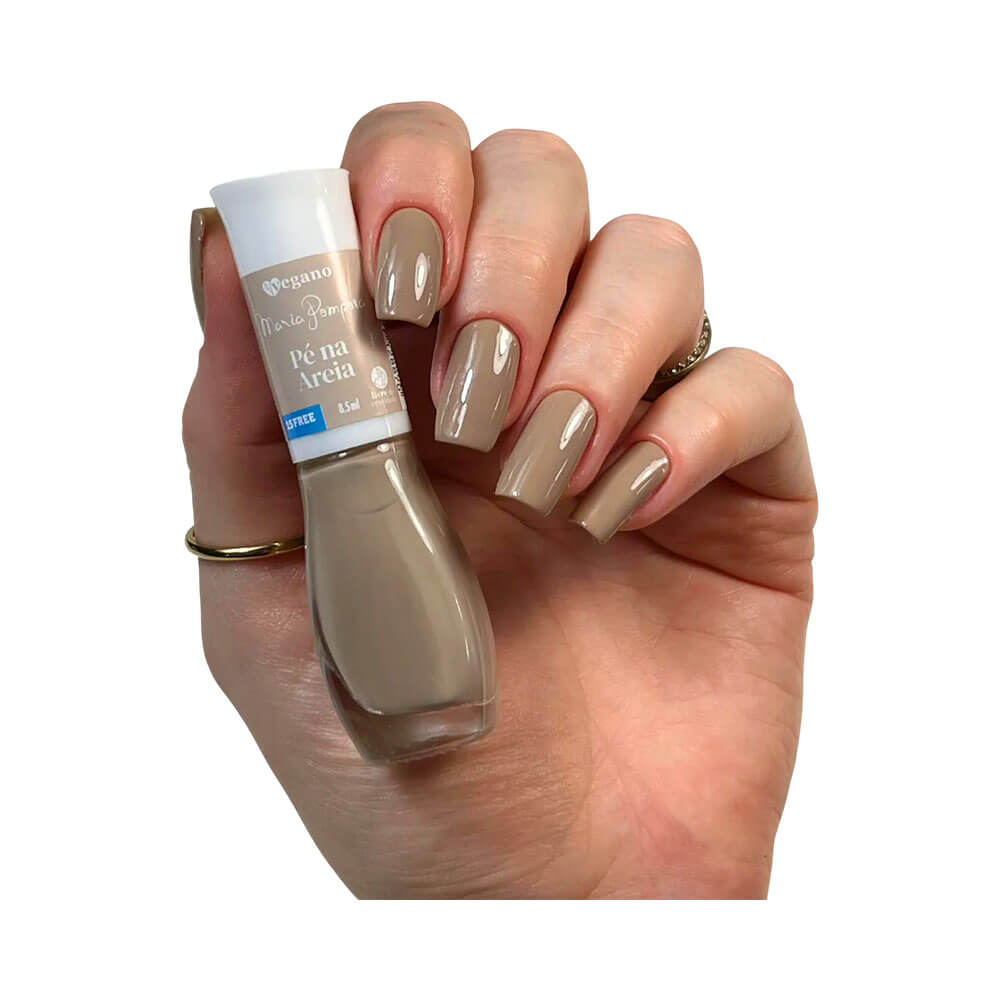 Mão feminina com unhas pintadas com esmalte Maria Pomposa Tô de Nude